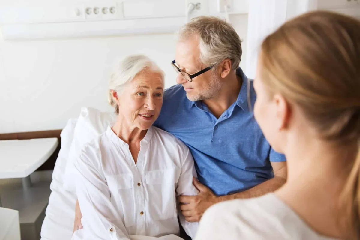 A family talking with an older woman in a care setting
